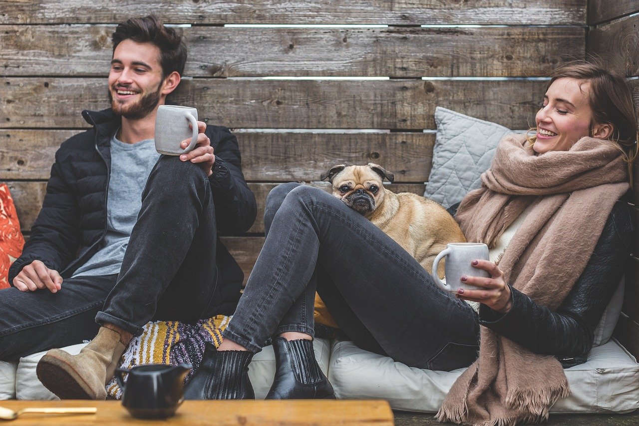 merry christmas, man, woman, dog, pet, pug, owners, couple, relationship, warm clothes, cozy, scarf, jackets, jeans, boots, fashion, people, happy, love, female, young, male, adult, caucasian, happiness, romantic, portrait, smile, smiling, girlfriend, date, boyfriend, together, person, lovers, sitting, relaxing, rustic, cushions, couch, laughing, enjoying, animal, coffee